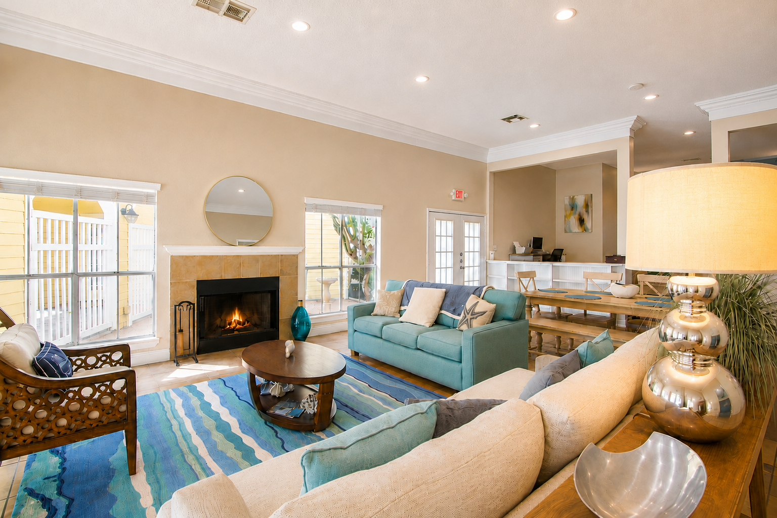 Resident clubhouse lounge with fireplace, coastal decor and dining area